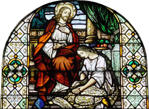stain glass window portraying woman anointing Jesus Christ's feet
